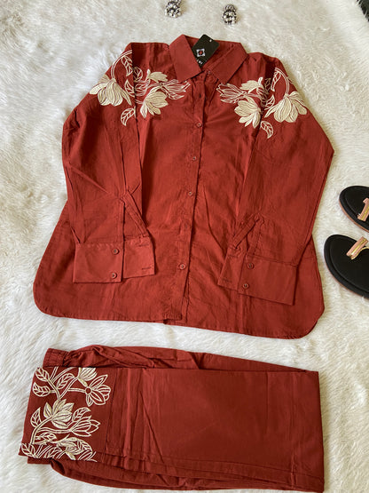 Red outfit with floral embroidery on a white surface