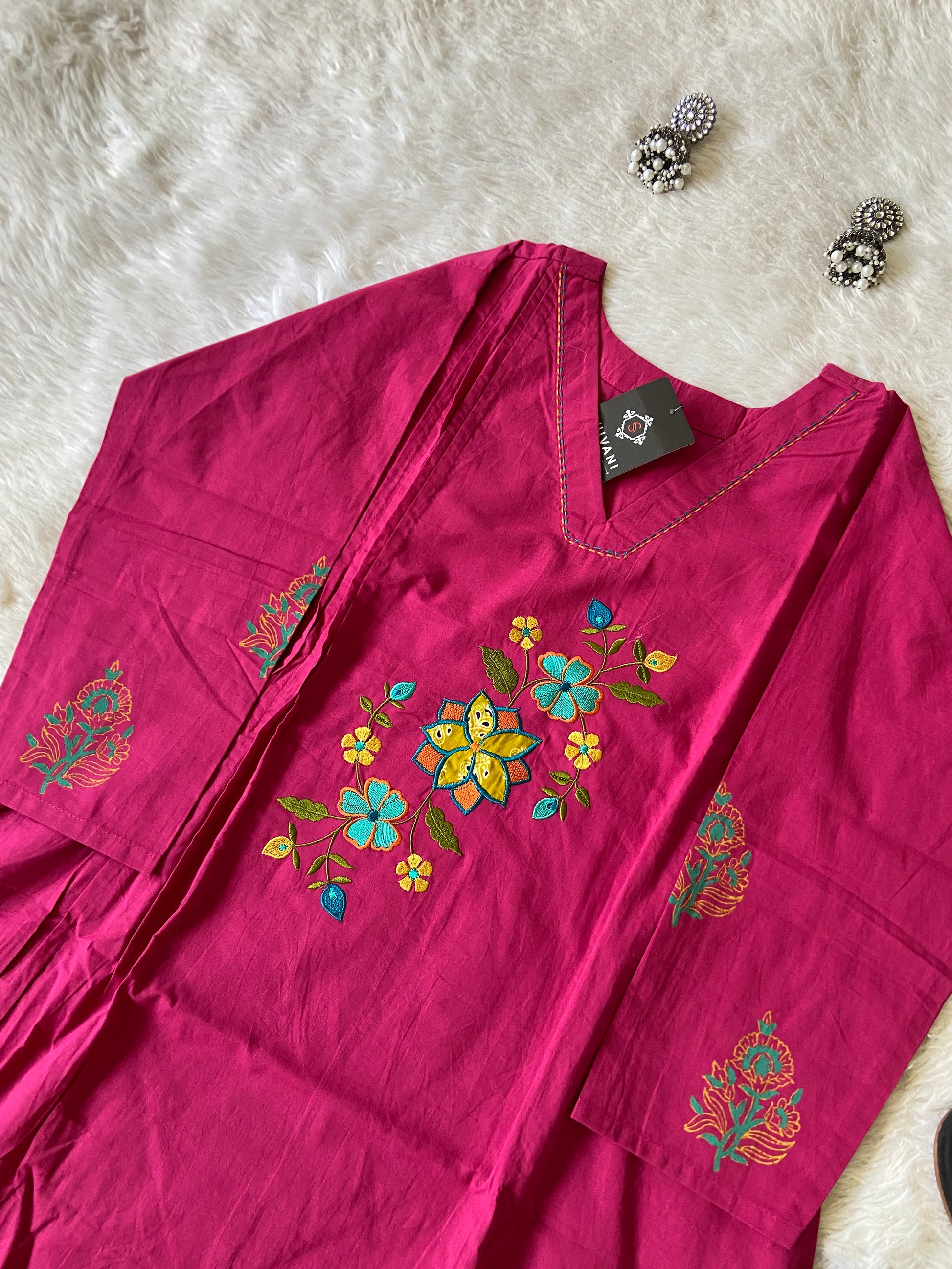 Maroon fabric with floral embroidery on a white fur surface