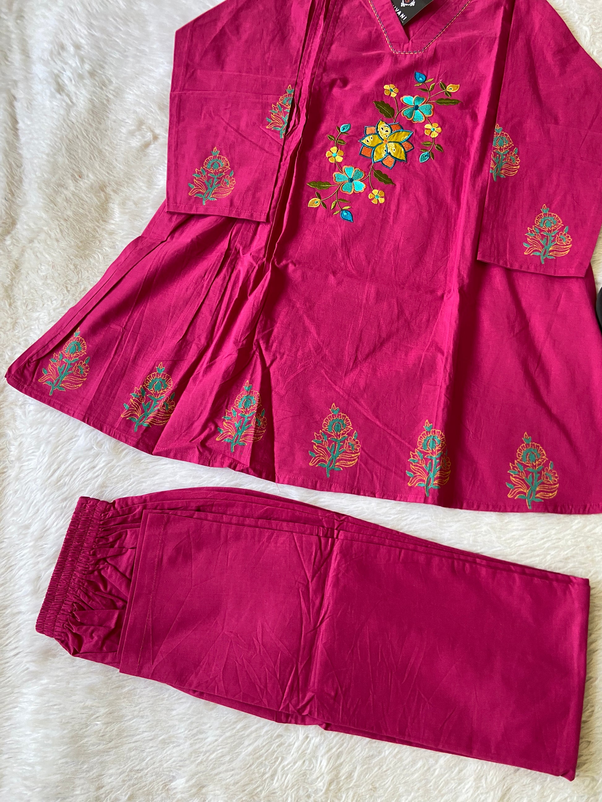 Pink embroidered outfit on a white surface