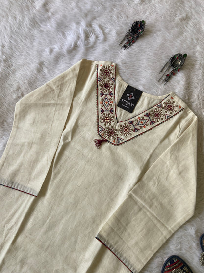 Beige kurta with intricate embroidery on a white fabric background