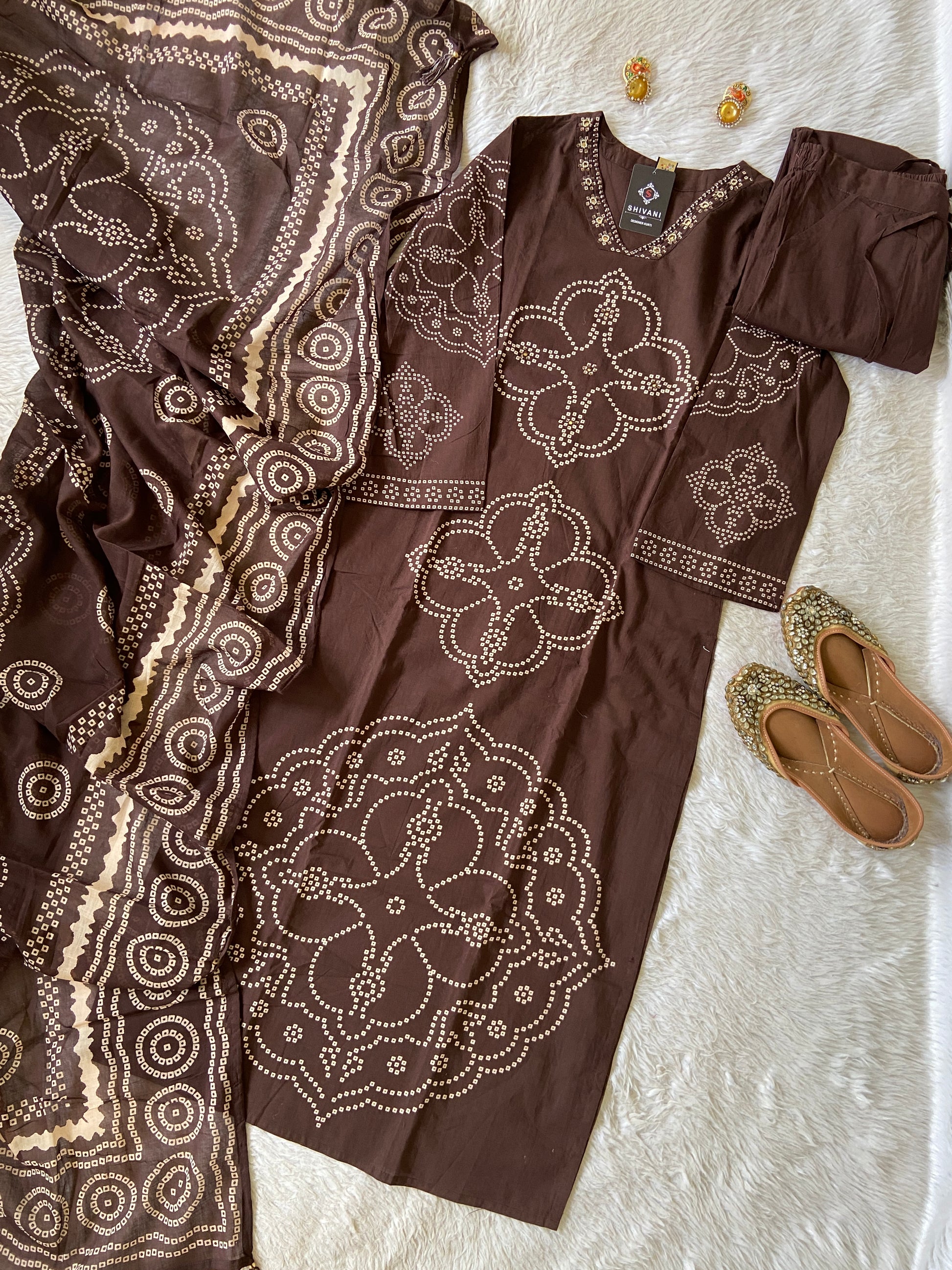 Brown outfit with intricate white patterns on a textured surface
