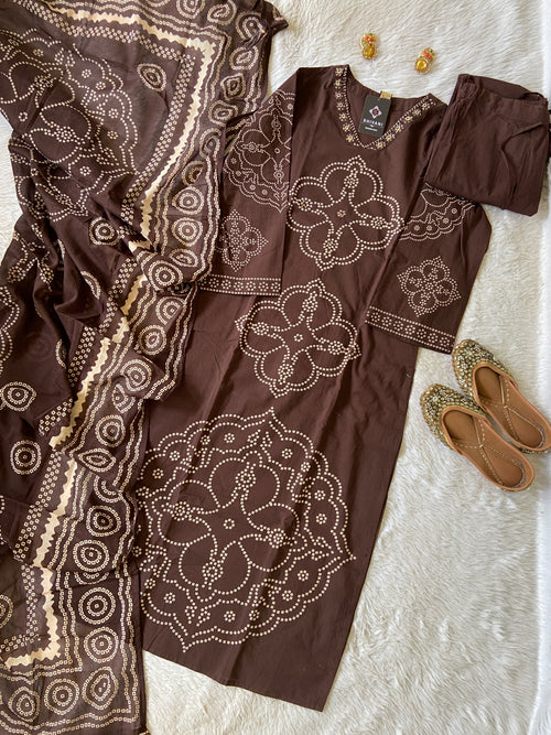 Brown outfit with intricate white patterns on a textured surface