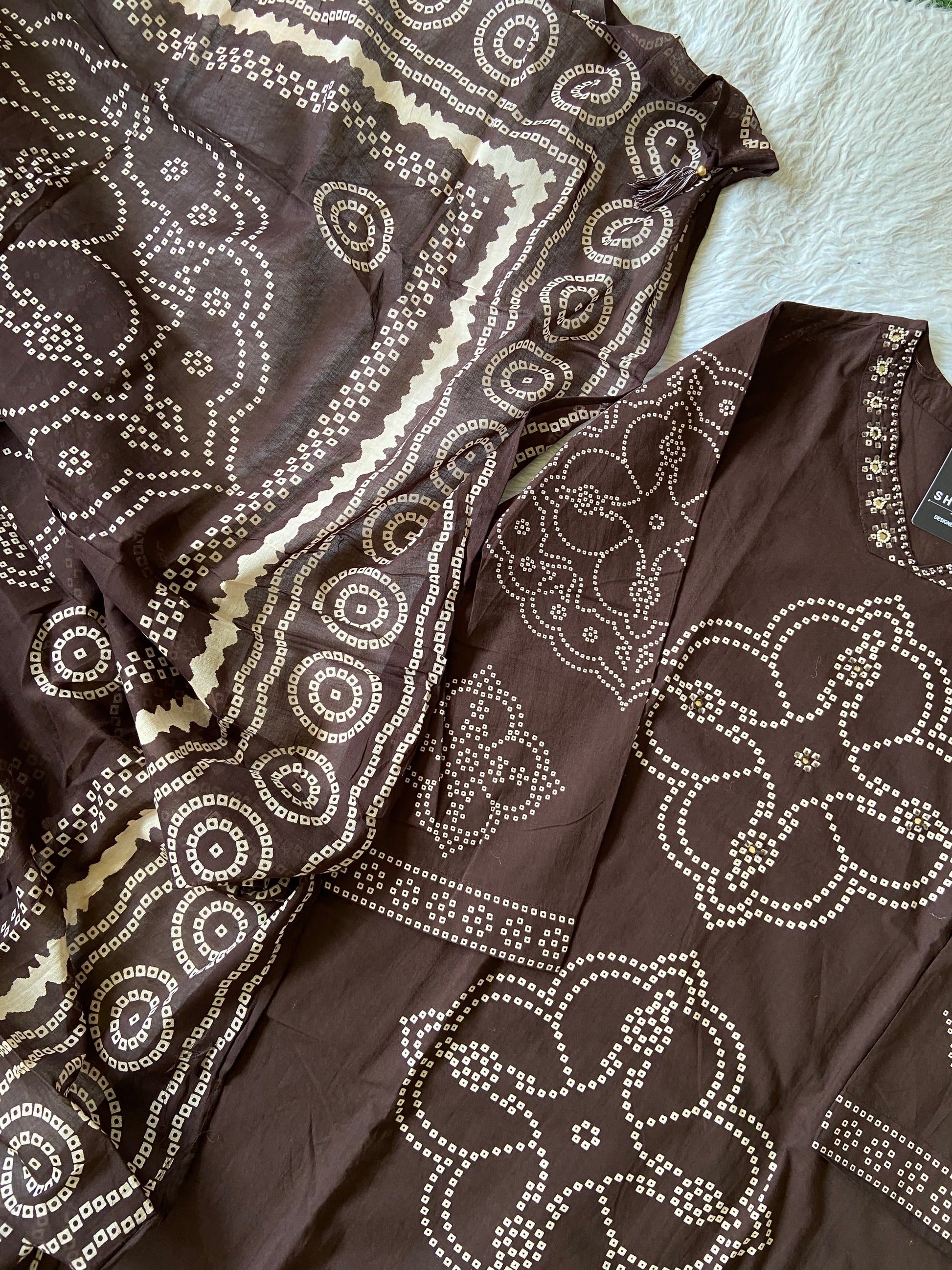 Brown blouse with white floral patterns on a white surface