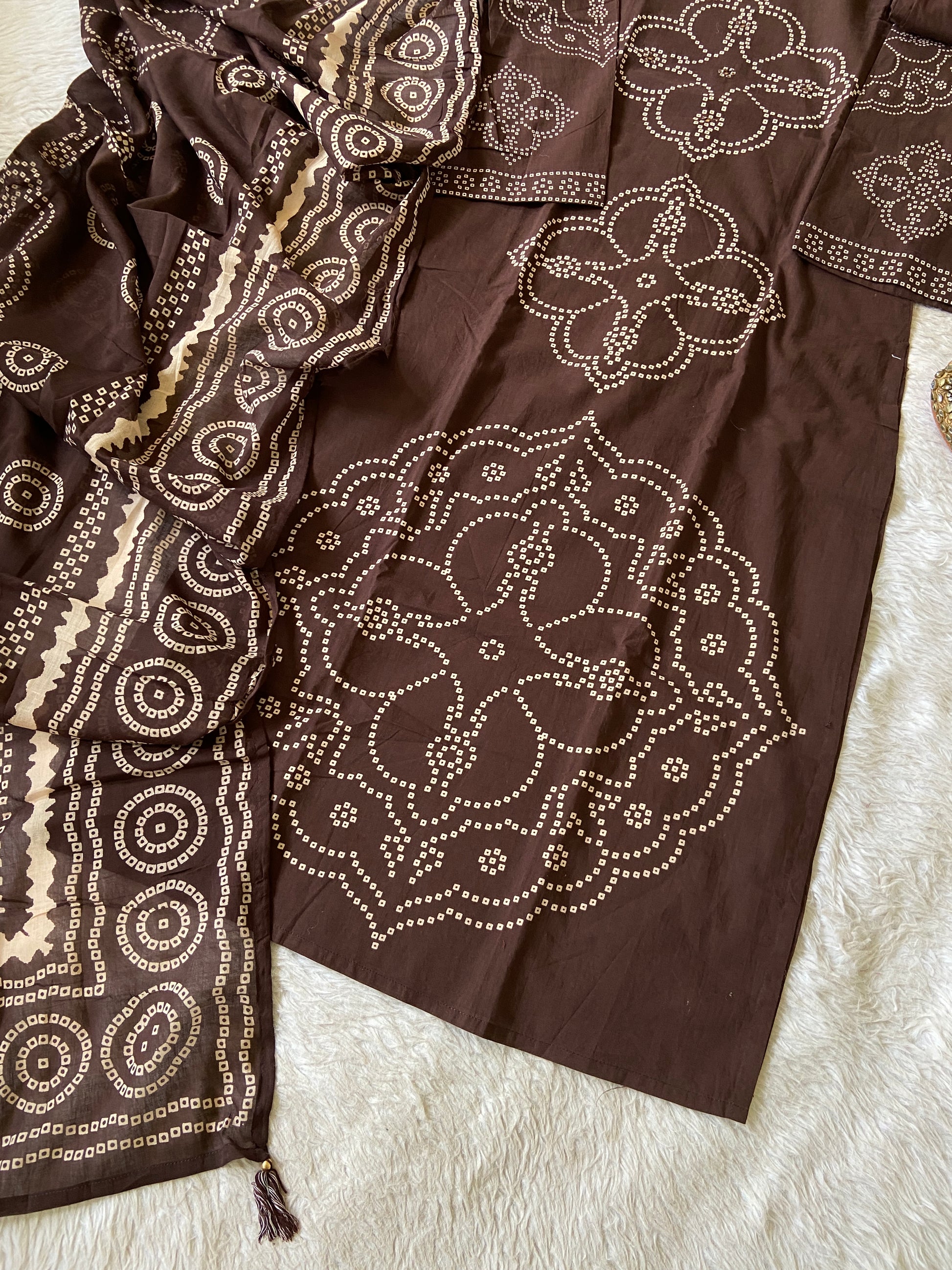 Brown fabric with white embroidery on a textured surface