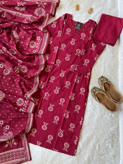 Red floral patterned outfit with a scarf and shoes on a white surface