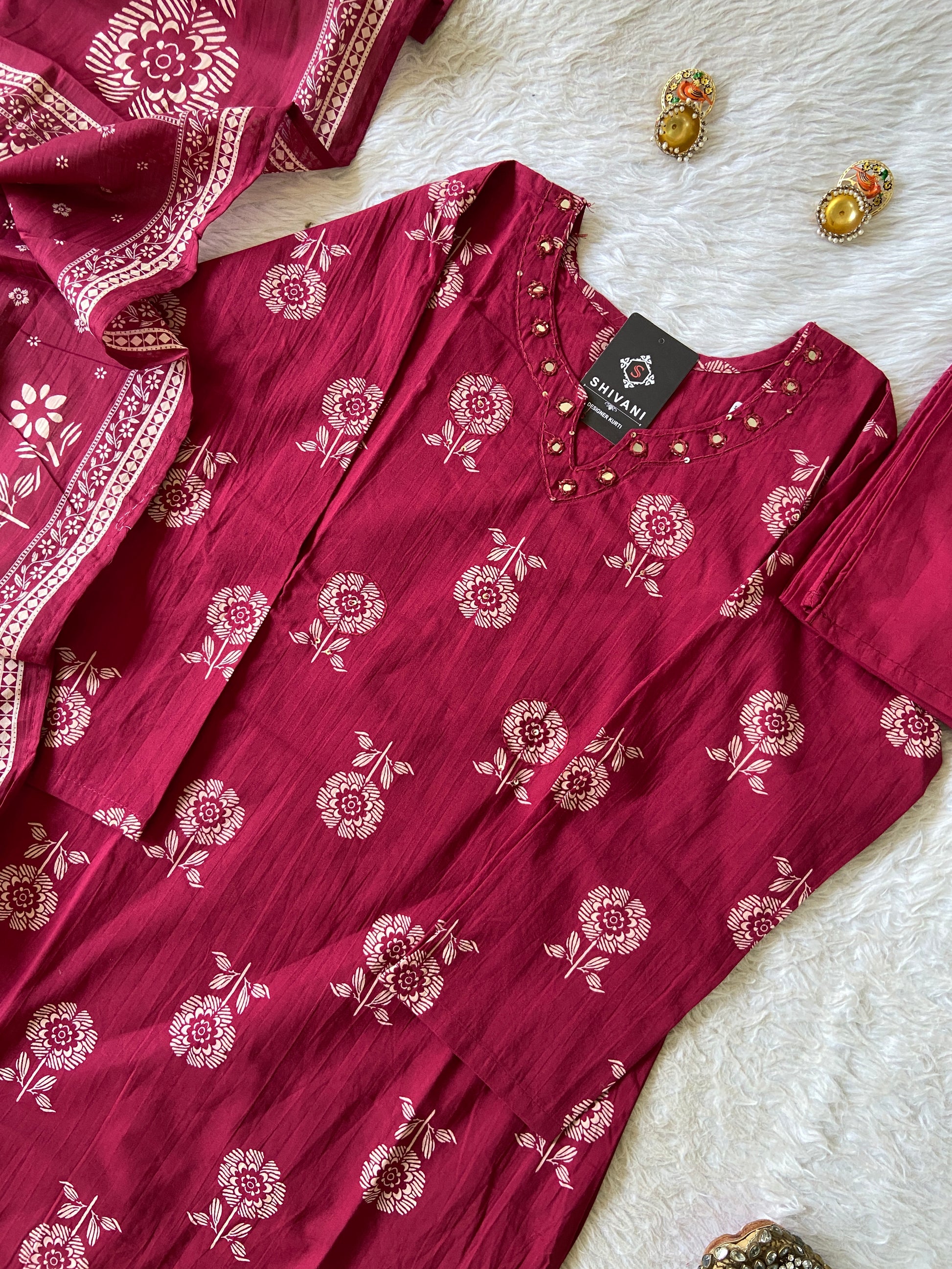 Red floral patterned dress with a tag on a textured white surface