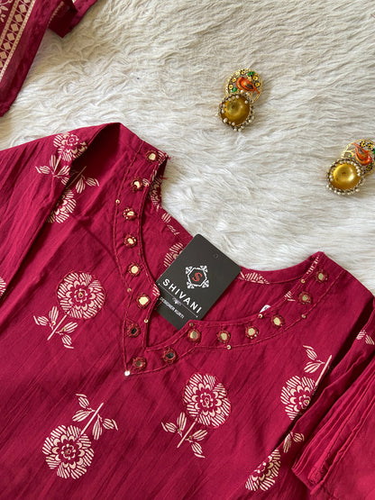 Red floral-patterned shirt with a 'Shivani' tag on a textured white surface.