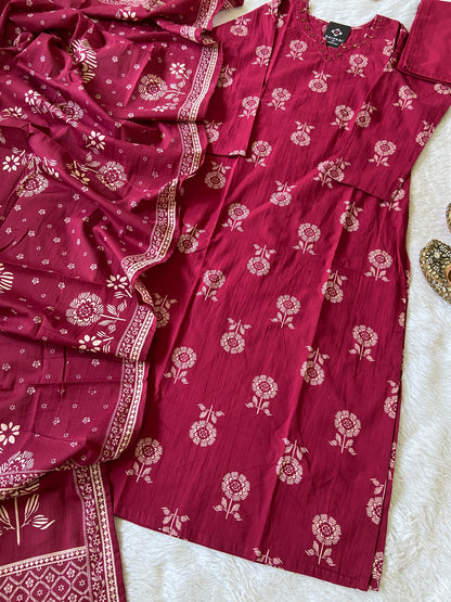 Red floral patterned outfit with matching dupatta on a white surface