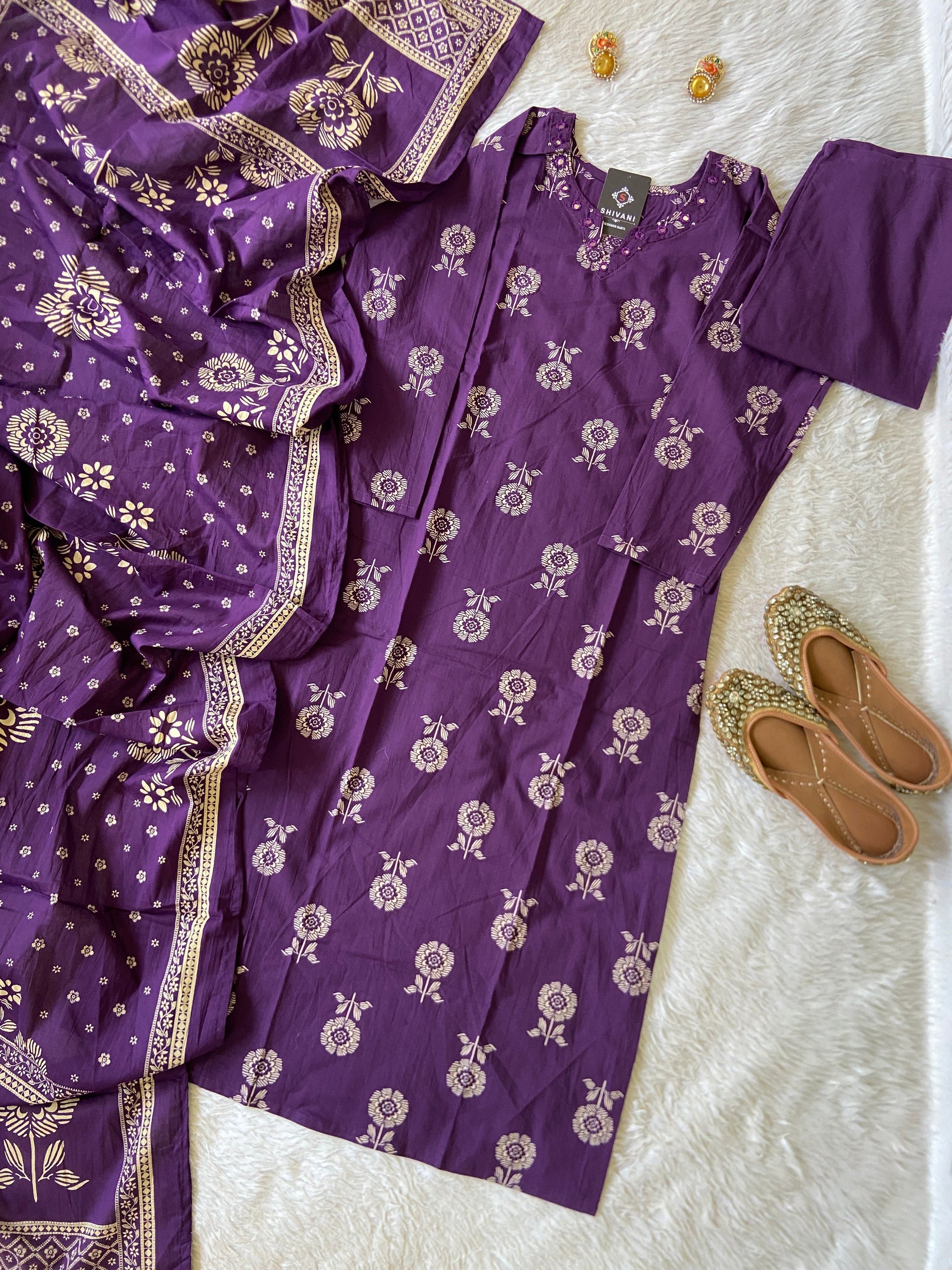 Purple saree with floral patterns on a white surface