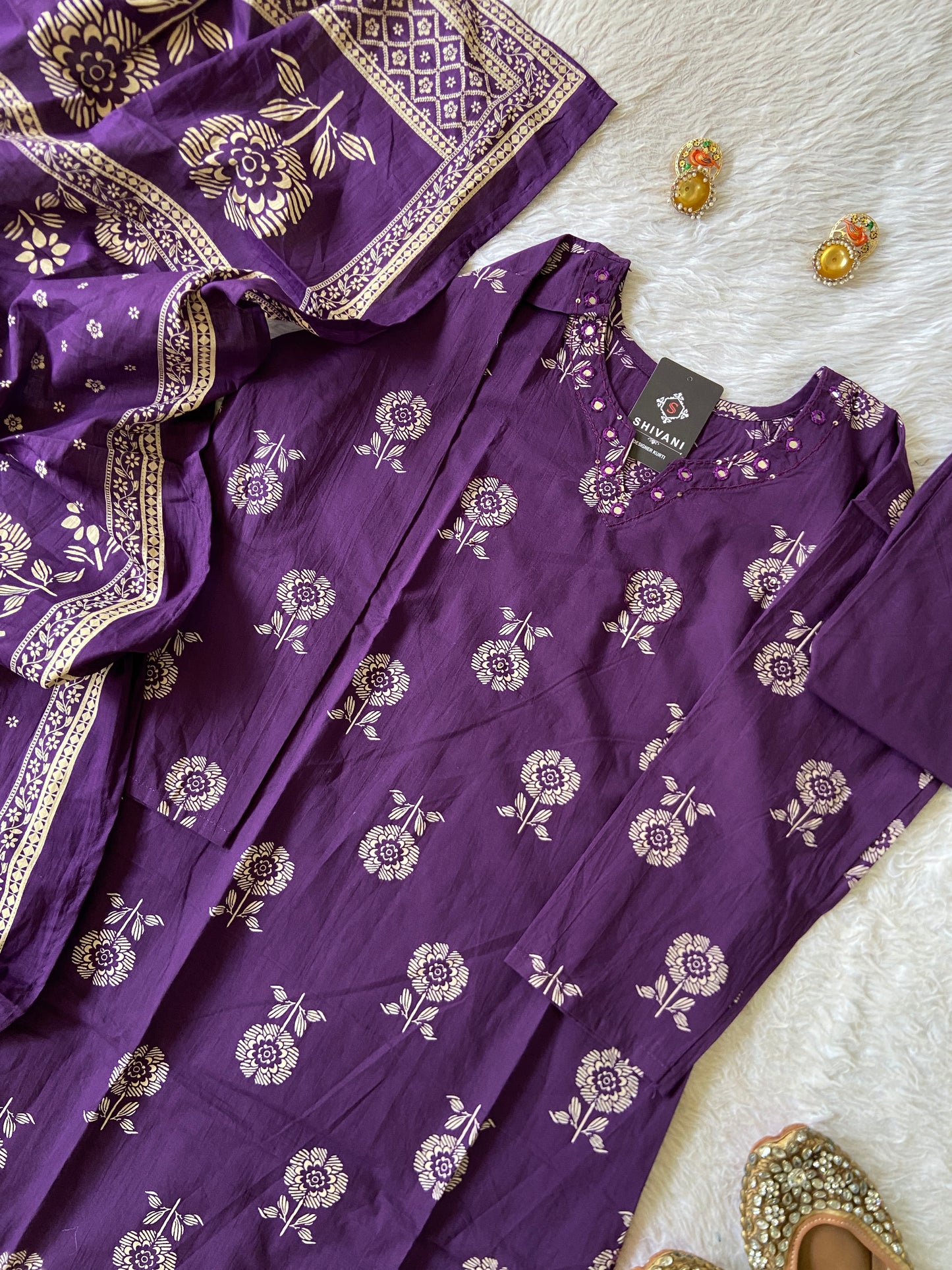 Purple fabric with floral patterns on a white surface