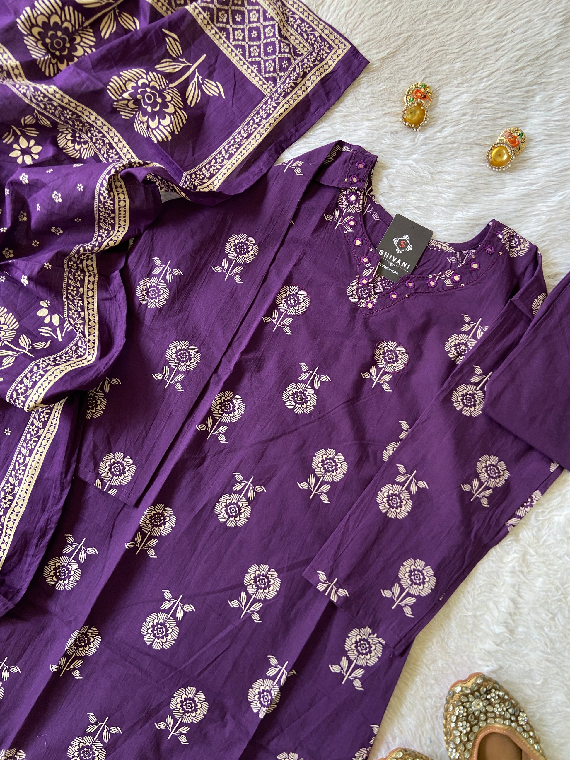 Purple fabric with floral patterns on a white surface