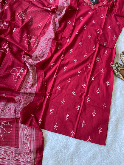 Red saree with white patterns on a light gray surface