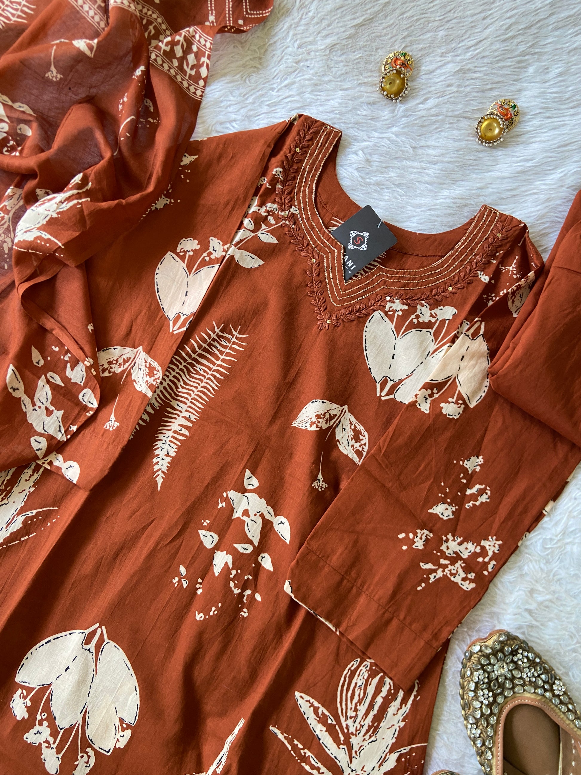Brown fabric with white floral patterns on a textured surface
