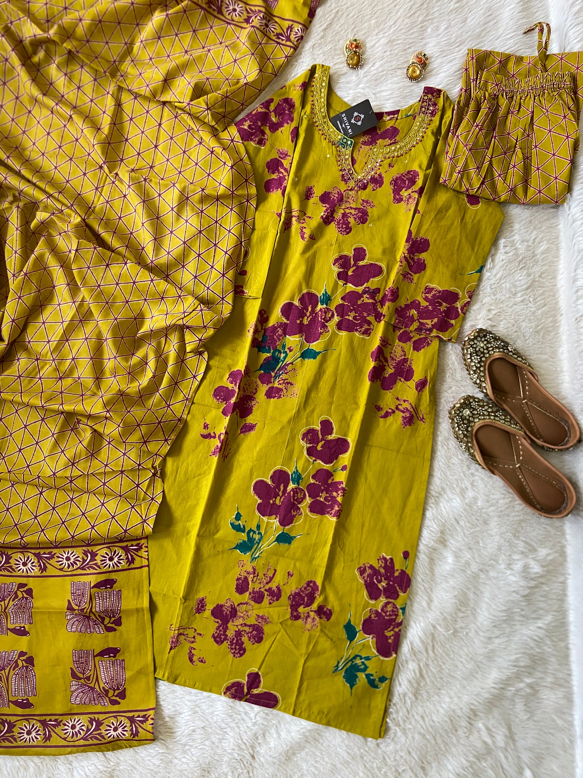 Yellow floral dress with matching shoes on a white surface
