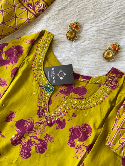 Yellow and purple patterned fabric with 'Shivani' tag on a white surface