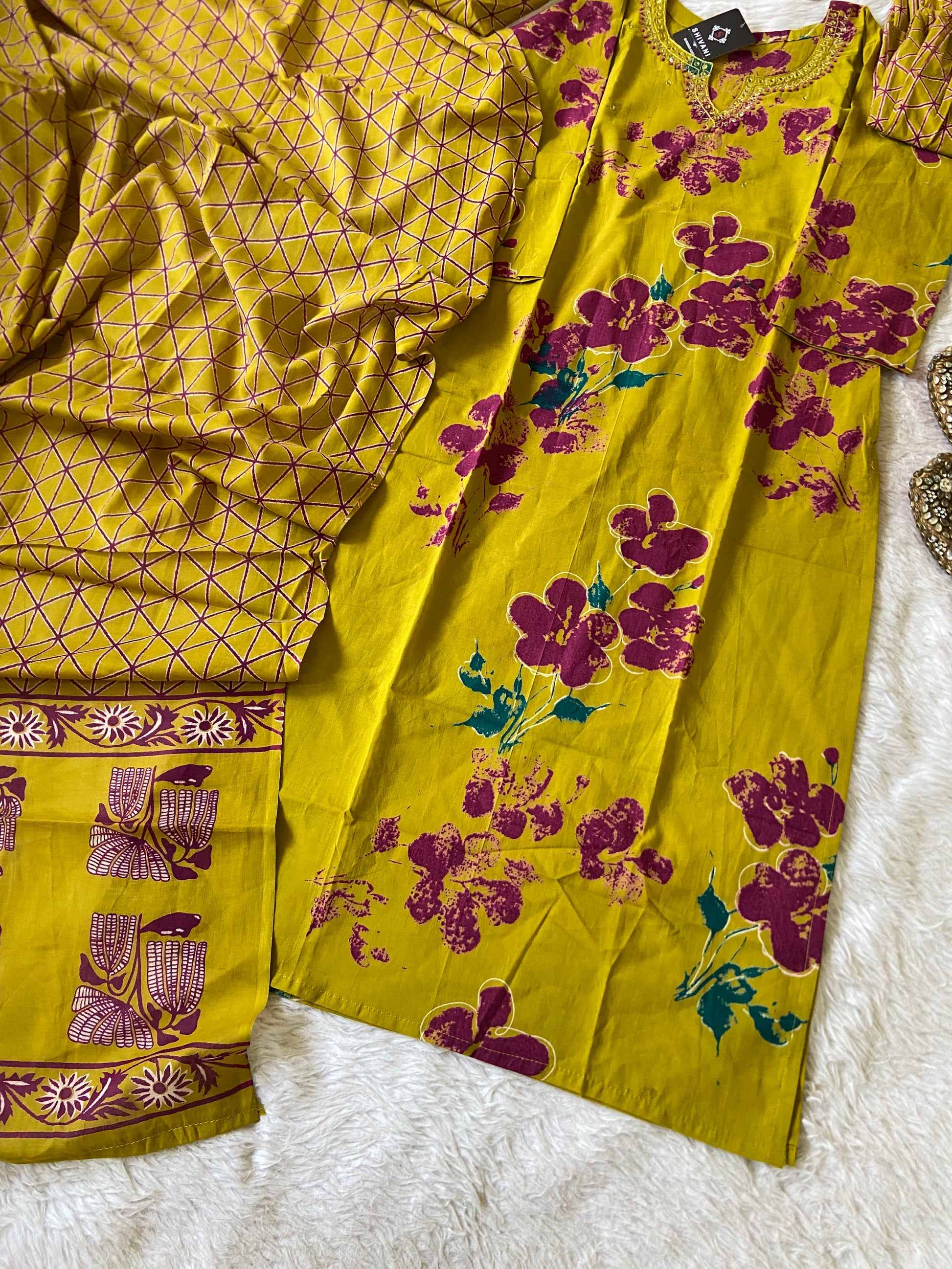 Yellow fabric with purple floral patterns on a white surface