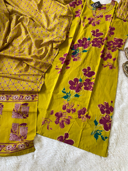 Yellow fabric with purple floral patterns on a white surface