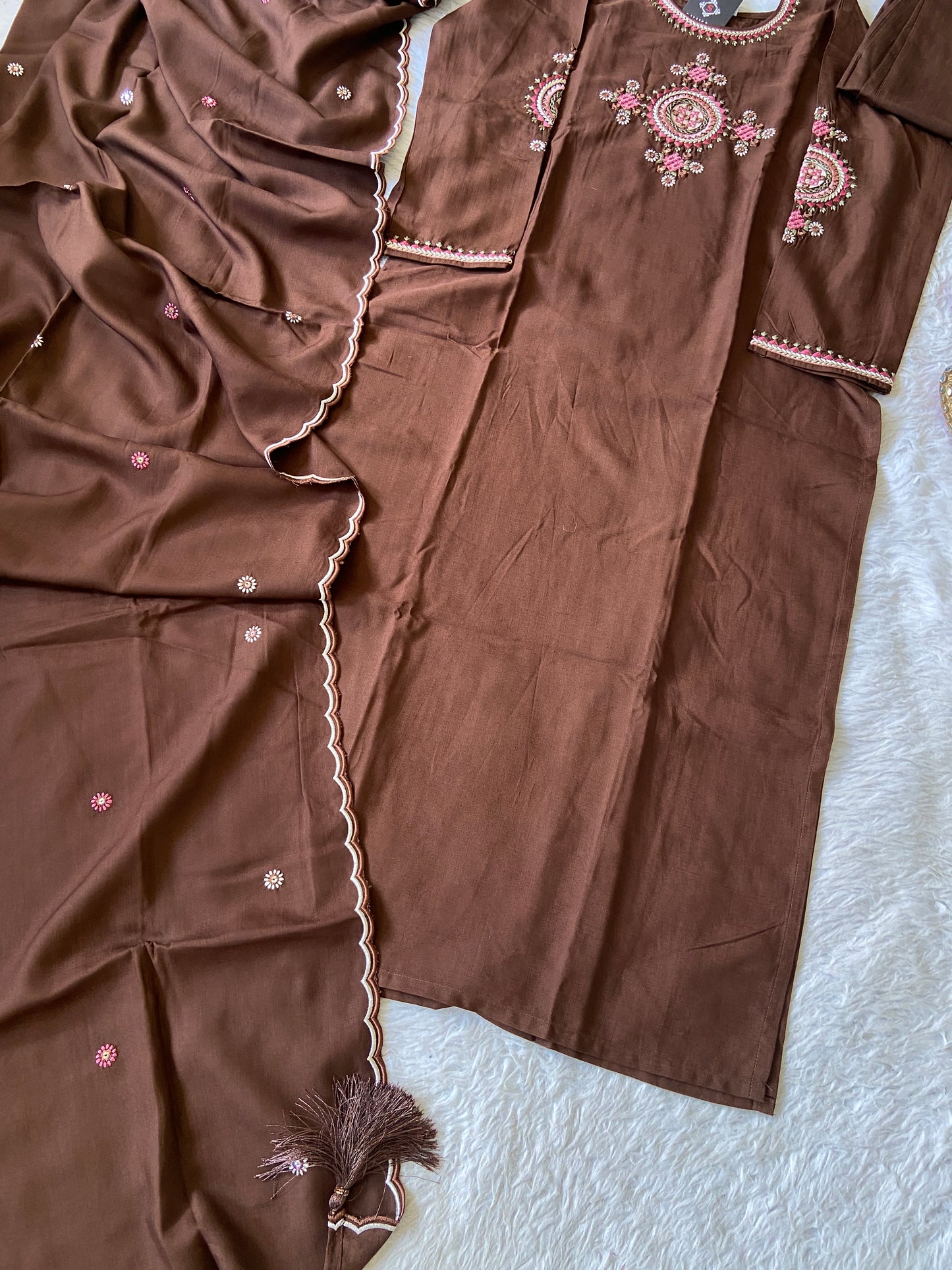 Brown fabric with embroidered patterns on a textured surface