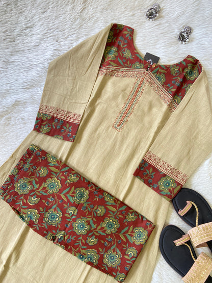 Traditional outfit with red and beige floral patterns on a white surface