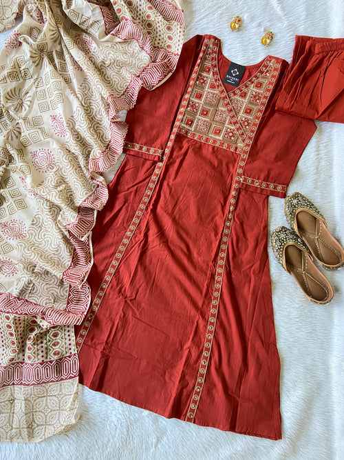 Red embroidered dress with a white and red patterned dupatta on a white surface.